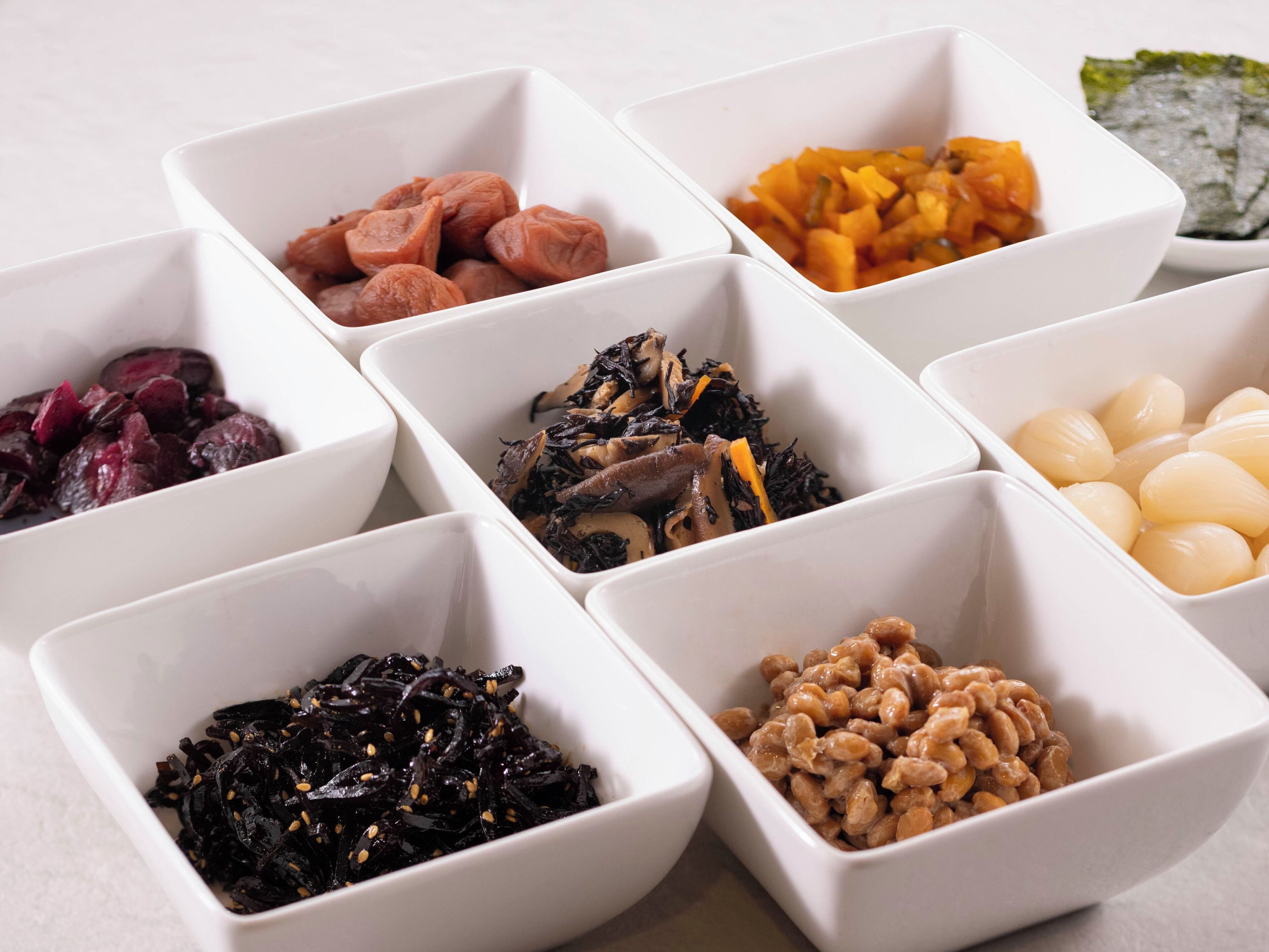 Variedad de alimentos en recipientes blancos.