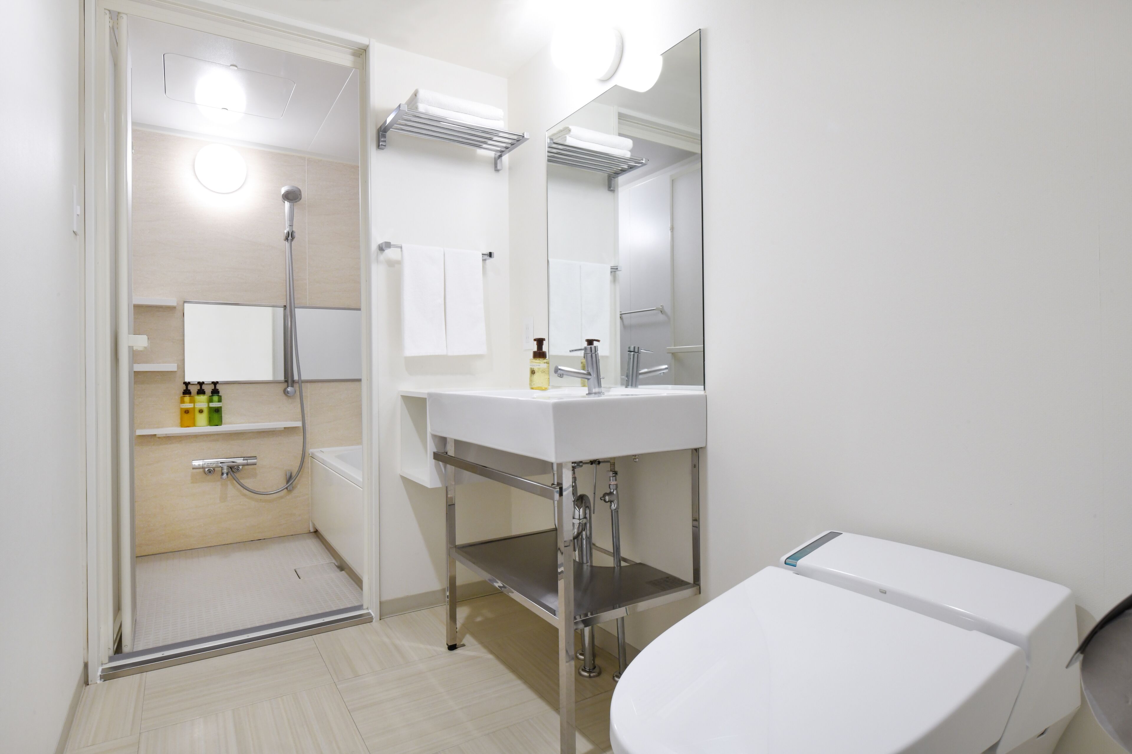 A modern bathroom with a shower, sink, and toilet.