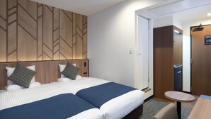 A hotel room with two beds, a small table, and a wardrobe. - HOTEL MYSTAYS Atsugi (Atsugi)