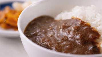 Un tazón de sopa de frijoles negros con arroz blanco.