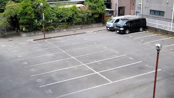 A parking lot with marked spaces, a black van, and a building in the background.