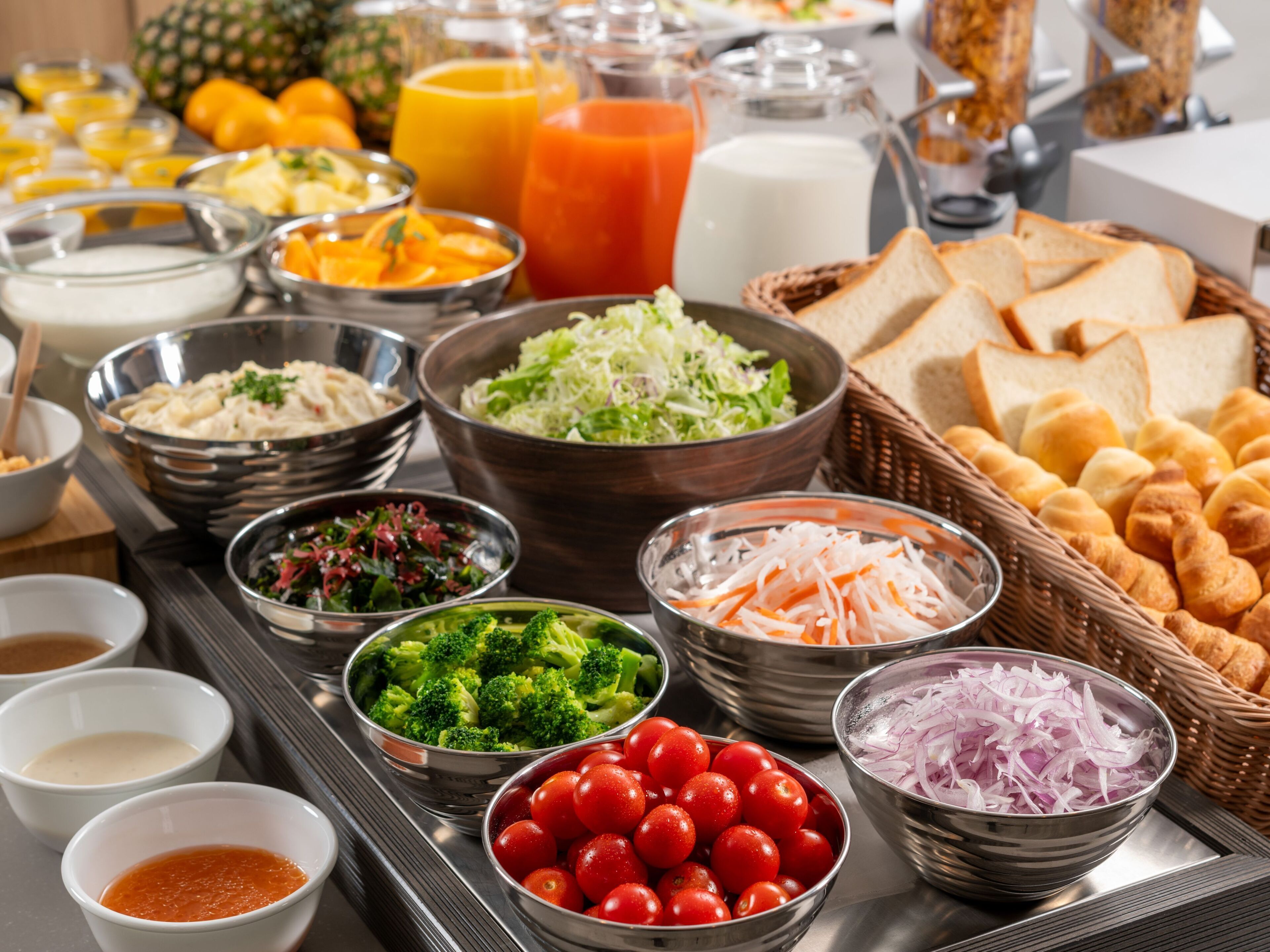 A buffet spread with various food items including salads, fruits, and bread.