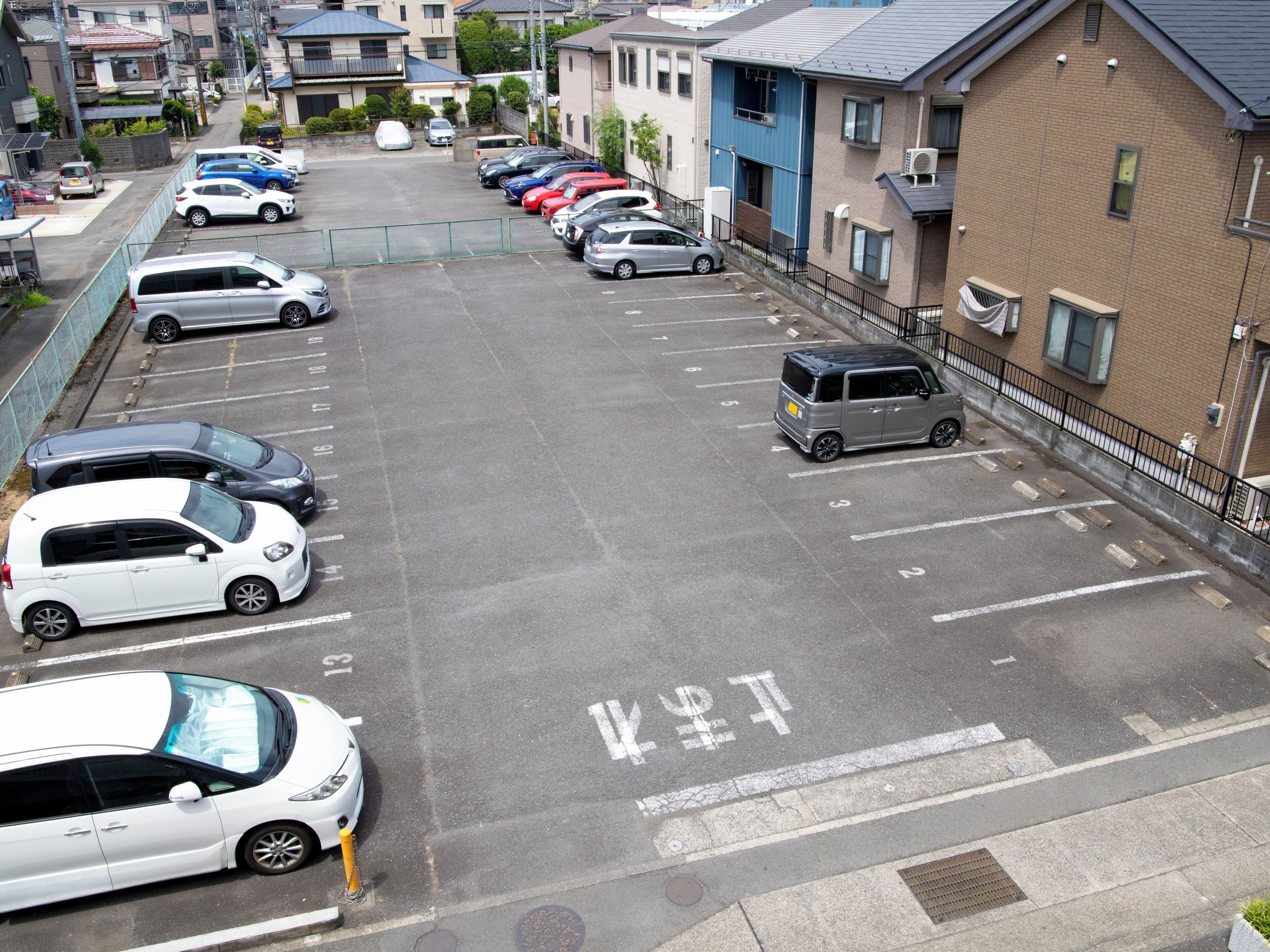 A parking lot with multiple cars and a building with a blue exterior.