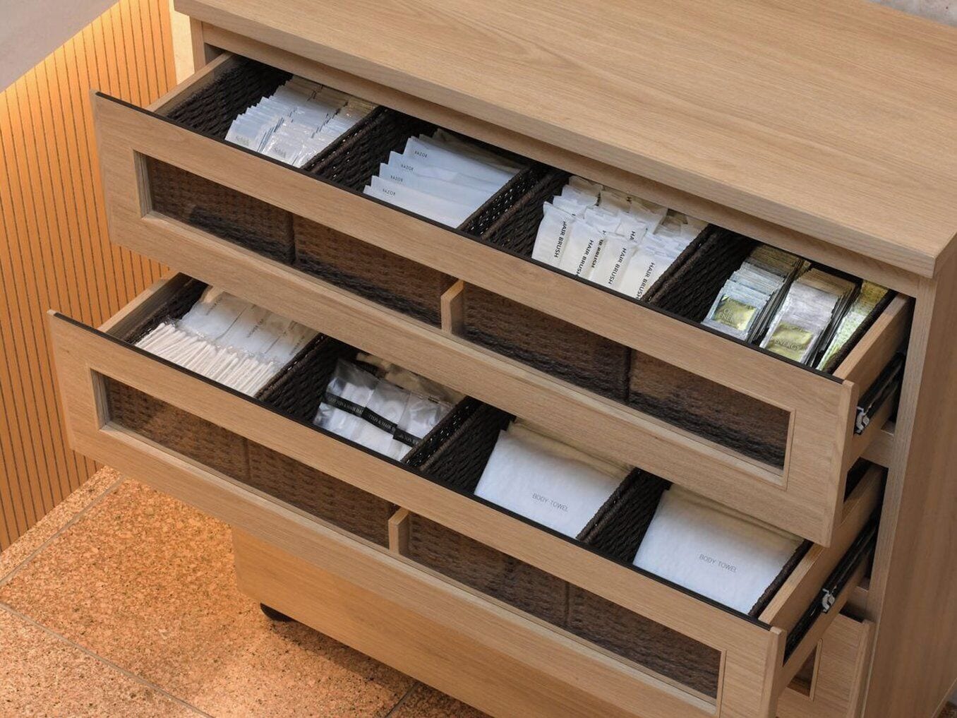 Un archivador de madera con varios cajones, cada uno conteniendo documentos y carpetas ordenados.