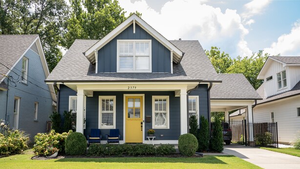 A two-story house with a front porch, a yellow door, and a mailbox. - Luxury Design, Prime Location 2 Minutes from Midtown, Family Fun! (Memphis)