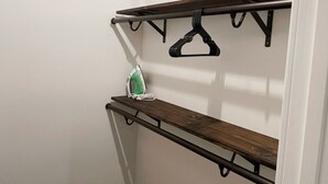 A closet with two wooden shelves and a hanging rod. - Charming 2-Bed Apartment in Houston (Houston)