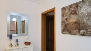 A hallway with a white console table, a mirror, and a Buddha statue. - T3  Familiar Albufeira, wifi, a/c, praia a 500m (Albufeira)