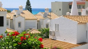 A coastal residential area with white buildings, red-tiled roofs, and a view of the sea. - T3  Familiar Albufeira, wifi, a/c, praia a 500m (Albufeira)