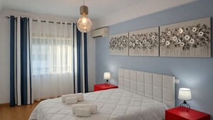 A bedroom with a bed, two bedside tables, a hanging light fixture, and three wall art pieces. - T3  Familiar Albufeira, wifi, a/c, praia a 500m (Albufeira)