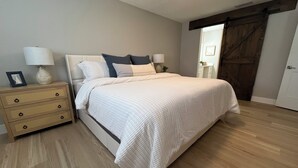 Un dormitorio con una cama, cómoda de madera y ventilador de techo.