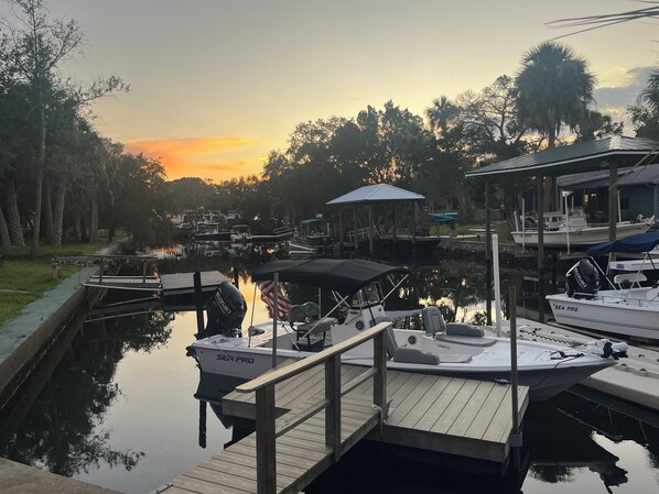 A marina with boats docked, a wooden dock, and a gazebo.