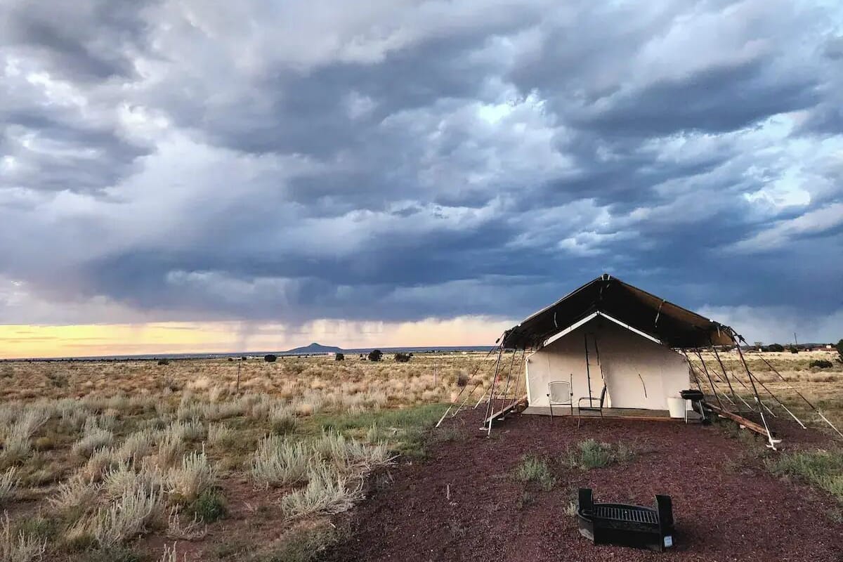 A small, single-story building with a sloped roof, situated in a dry, grassy field.