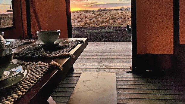 A wooden deck with a view of a desert landscape at sunset. - Raptor Ranch (Williams)
