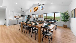 A spacious dining area with a long wooden table set for multiple people, surrounded by chairs. - Cozy Lakeview Lodge - Pools, Private Hot Tub & Sauna, Game Room (Branson)