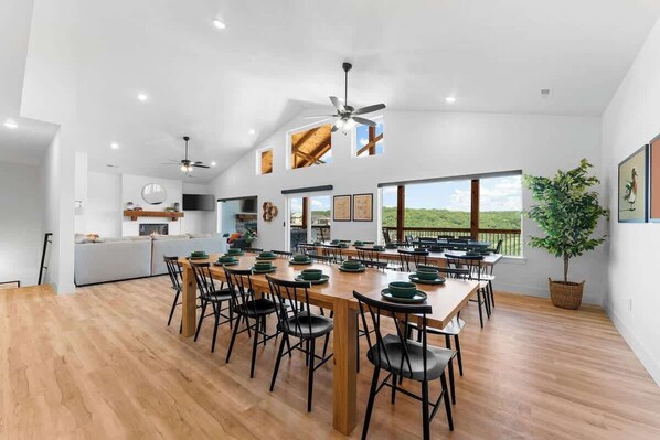 A spacious dining area with a long wooden table set for multiple people, surrounded by chairs. - Cozy Lakeview Lodge - Pools, Private Hot Tub & Sauna, Game Room, 1 mile to SDC (Branson)