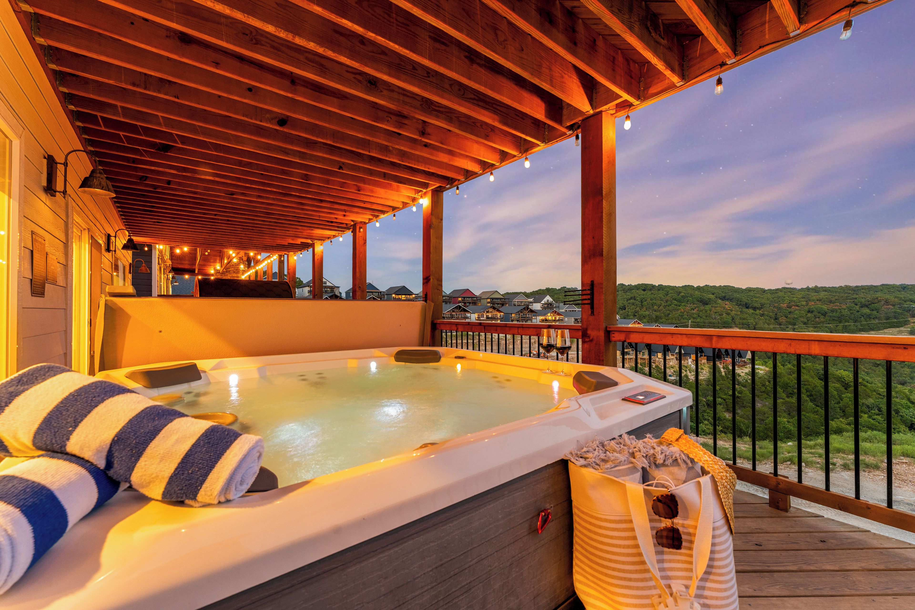 A hot tub on a wooden deck with a view of houses in the background.