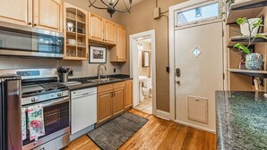 A kitchen with wooden cabinets, a stainless steel oven, a sink, and a chandelier. - Cozy, Historic Home in A++ Location!! (Denver)