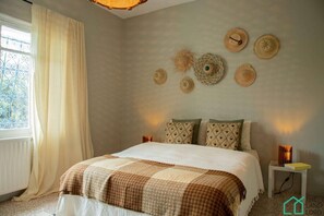 Une chambre à coucher comprenant un lit, une table de chevet et des éléments décoratifs fixés au mur.
