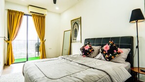 A bedroom with a bed, a nightstand, a lamp, a window with curtains, and a balcony. - Emporis SOHO Residence by Airhost  (Petaling Jaya)