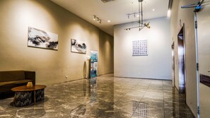 A spacious lobby with a marble floor, a sofa, a coffee table, and artwork on the walls. - Emporis SOHO Residence by Airhost  (Petaling Jaya)