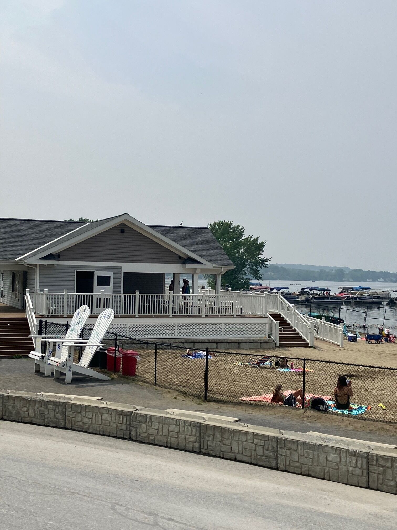 A beach house with a deck and stairs leading to a covered area.