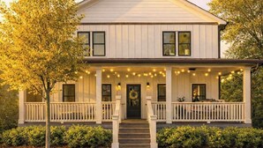 A two-story house with a porch, a front door, and a small front yard.