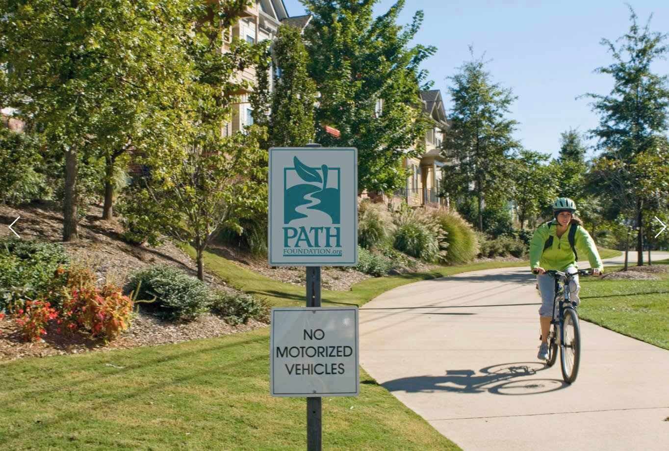 Una calle residencial con un ciclista y un cartel que indica que no se permiten vehículos motorizados.