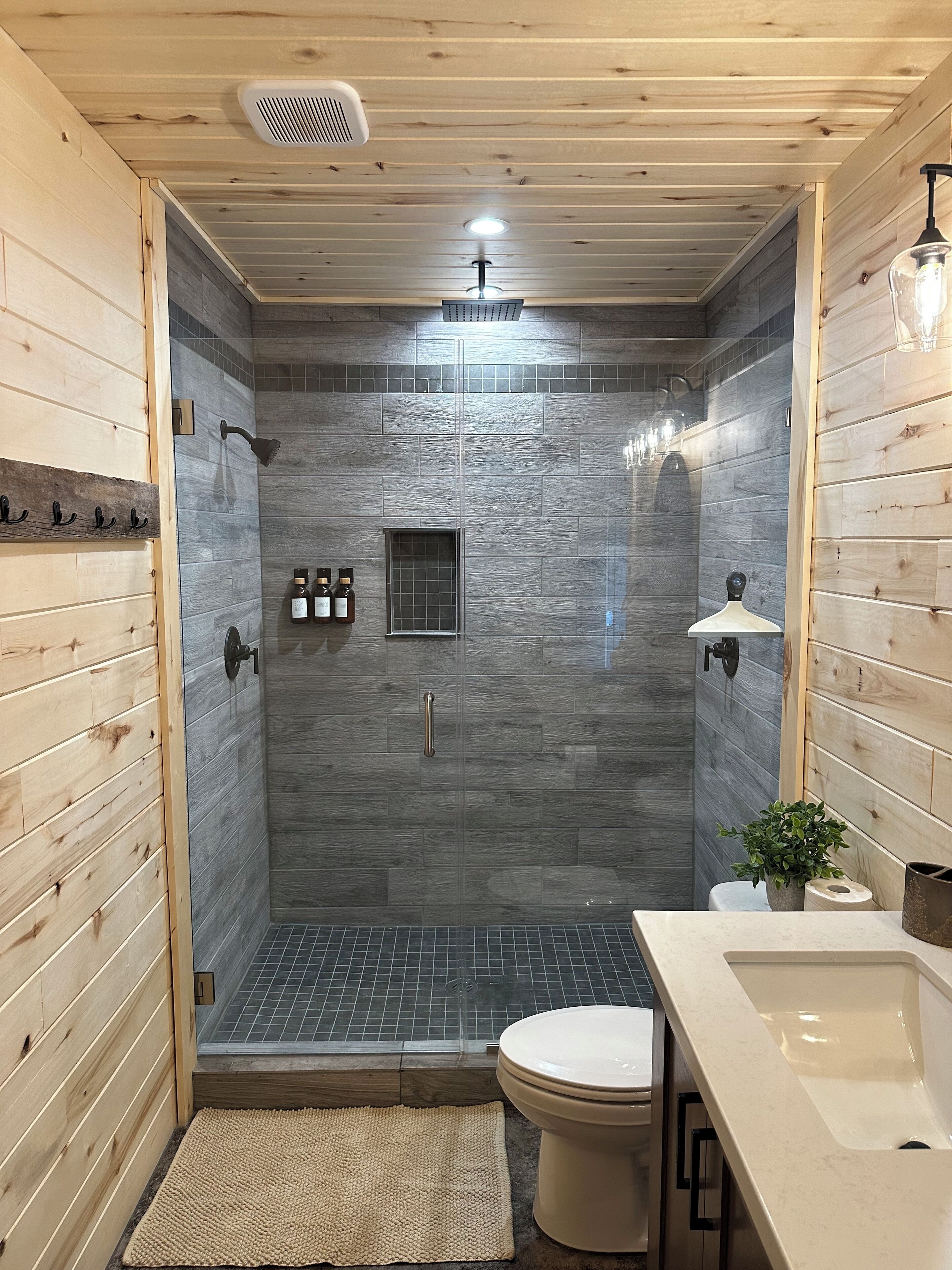 A modern bathroom with a shower, toilet, and sink.