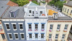 A row of colorful buildings with distinct architectural styles, including a building with a green roof and dormer windows. - Huge Retreat| Rooftop Deck| Stay At Findlay Market (Cincinnati)