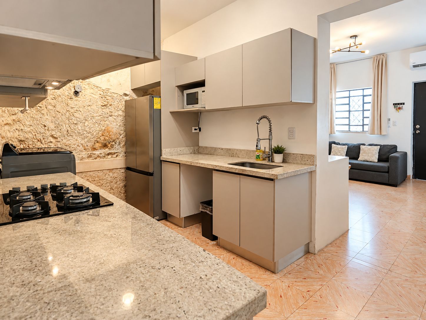 A modern kitchen with granite countertops, stainless steel appliances, and a built-in microwave.