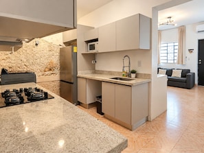 A modern kitchen with granite countertops, stainless steel appliances, and a built-in microwave.
