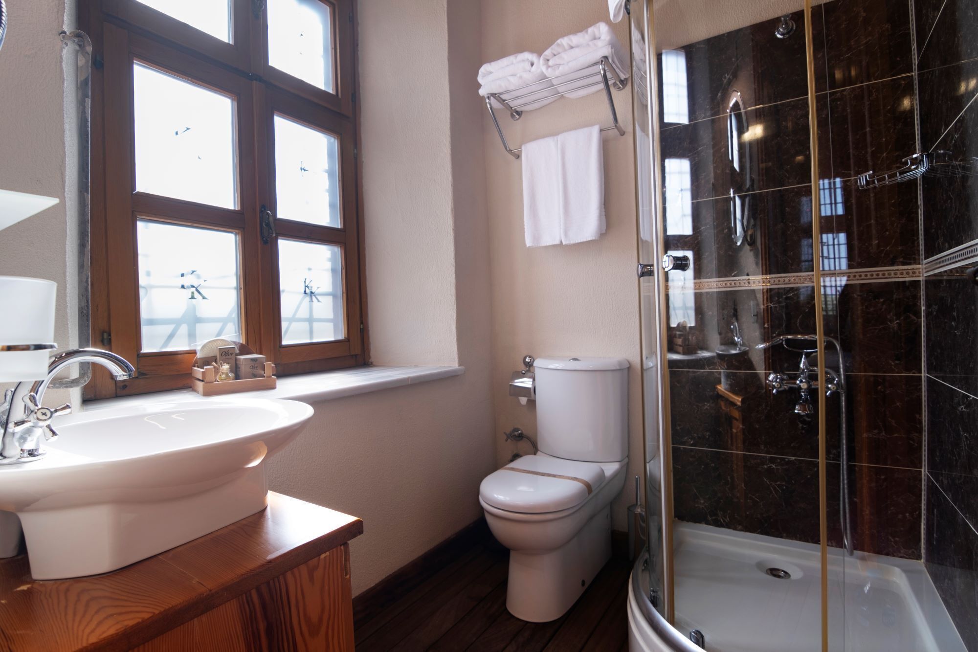 A bathroom with a sink, toilet, and glass-enclosed shower.