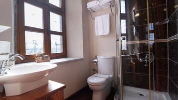 A bathroom with a sink, toilet, and glass-enclosed shower.
