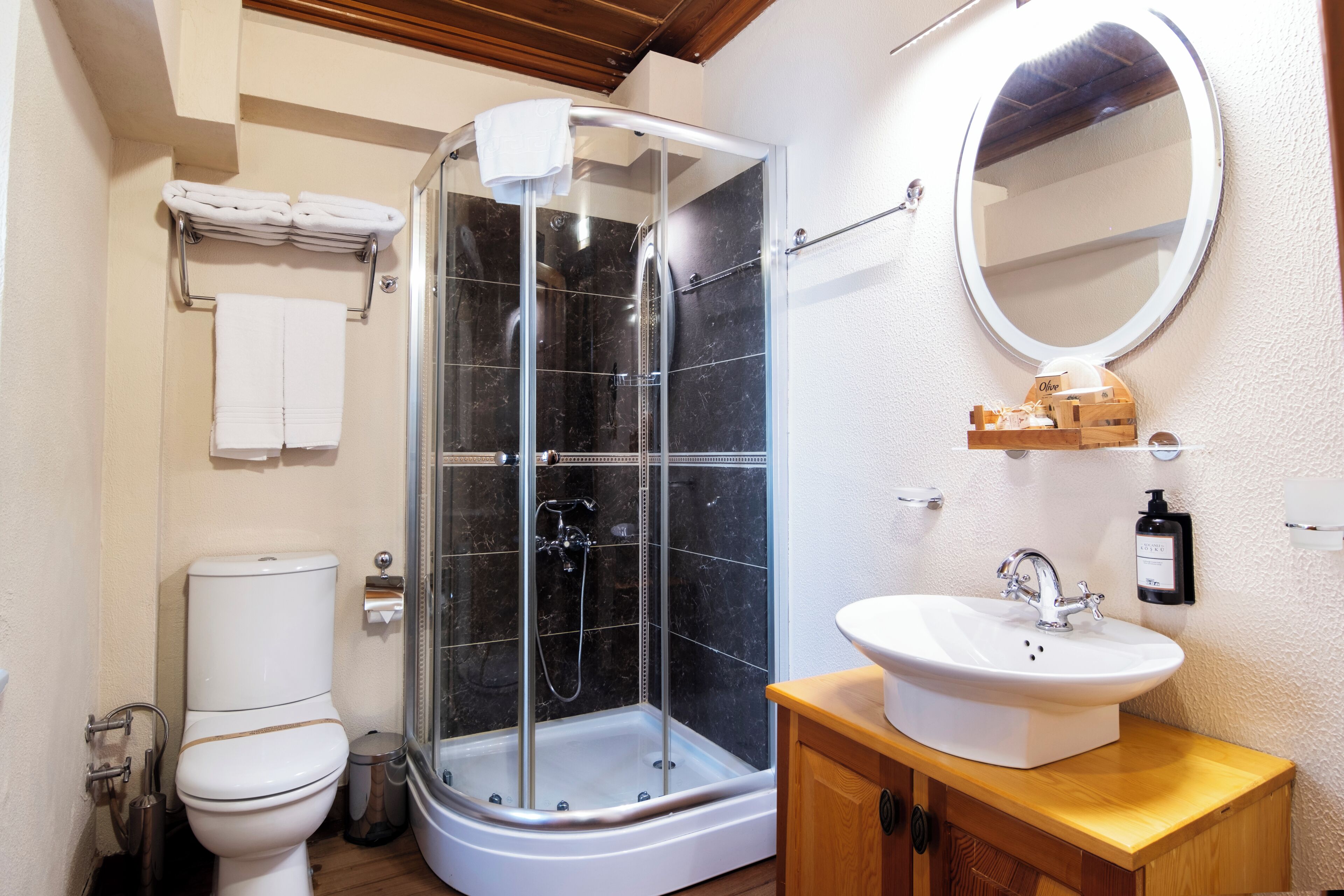 Un baño con ducha de vidrio, inodoro, lavamanos y espejo.