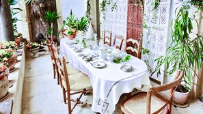 Enjoy a traditional dining experience with a beautifully set table, surrounded by lush greenery and classic decor.