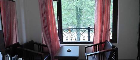 A room with a table and two chairs, a coffee maker, and a small tray with items.