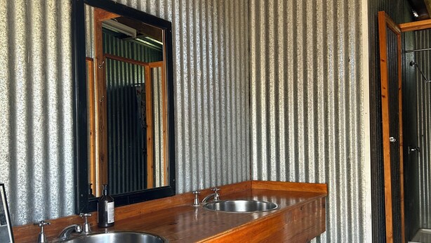 Une salle de bain avec un meuble-lavabo en bois, deux vasques et un miroir.