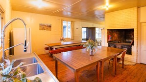 Une cuisine avec une table en bois, un évier et une cheminée.