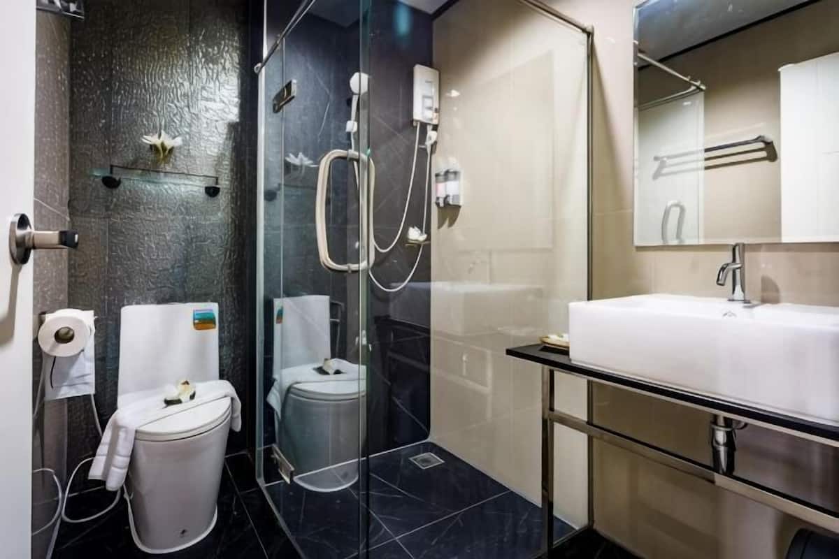 Ein modernes Badezimmer mit einer einteiligen Duschkabine, einem weißen Waschbecken und einer Toilette.