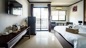 A hotel room with a bed, a desk, a TV, and a balcony. - Lux Boutique Hotel (Nonthaburi)