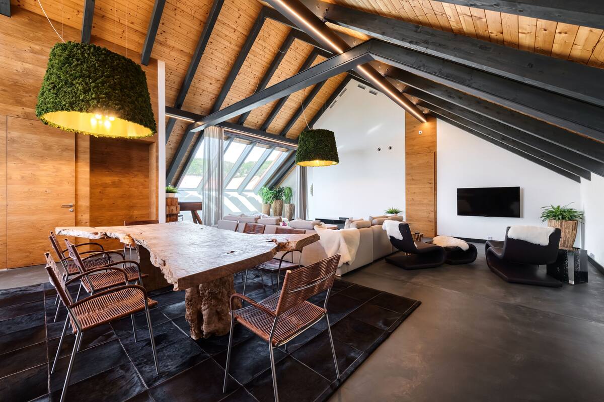 Un espacio habitable moderno tipo loft con una gran mesa de comedor, asientos y un televisor.
