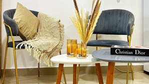 A room with two sofas, a small round table, and a book titled 'Christian Dior'.