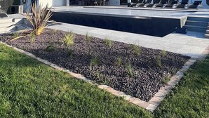 Una casa moderna de dos pisos con piscina, mobiliario exterior y un jardín bien cuidado.