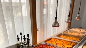 Een buffet met diverse gerechten, sauzen en bestek.