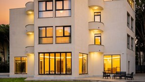 Een modern meerlaags gebouw met balkons, grote ramen en terrasjes.