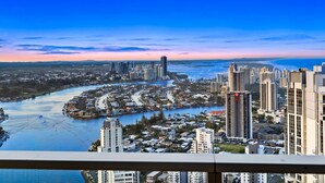A cityscape with high-rise buildings, a river, and a clear sky.