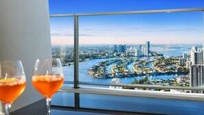 A high-rise hotel room with a panoramic view of a cityscape and a river.