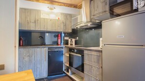 Cocina compacta con lavavajillas, horno y microondas integrado.