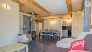Un espacio de sala acogedor con chimenea, una mesa de comedor y un sofá.