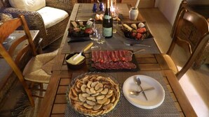 Una tavola imbandita con diverse pietanze, tra cui una torta, salumi e una bottiglia di vino.